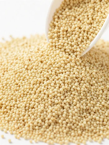 陶器のボウルに入った生のアマランサス、小さな黄色い粒