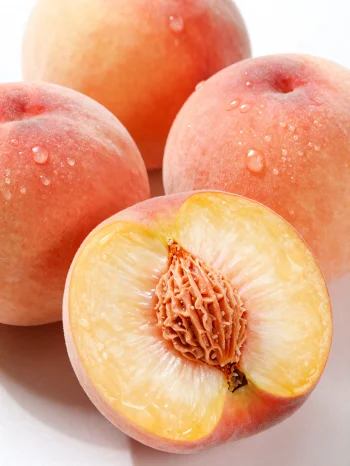 木製のテーブルに置かれた丸ごととスライスされた桃、桃ジュースのグラス