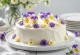 エディブルフラワーで飾られた春の花のケーキ
