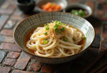 きしめん、濃厚なだし汁、新鮮な青ネギといりごまを添えた平打ちうどん